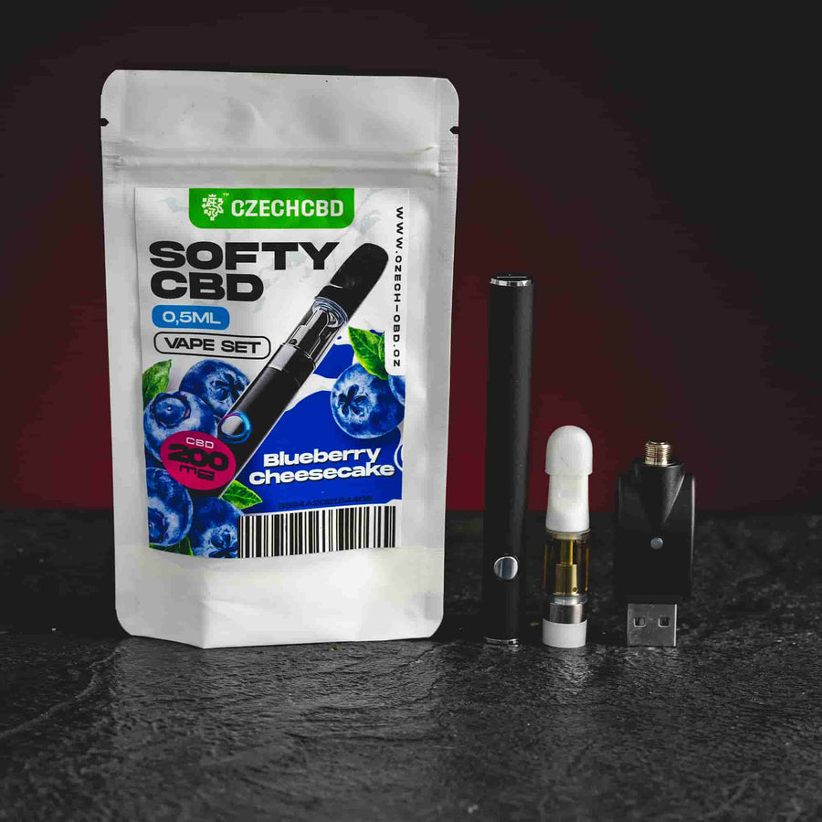 Softy CBD Vape Set Blueberry Cheesecake Kratom World, представен в продуктов кадър като CBD vape комплект с боровинково-чийзкейк профил.